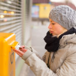 Frau wirft Brief in den Briefkasten