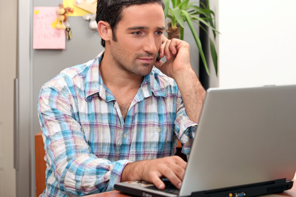 Mann telefoniert am Laptop