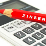 roter stift mit der aufschrift "Zinsen" und taschenrechner